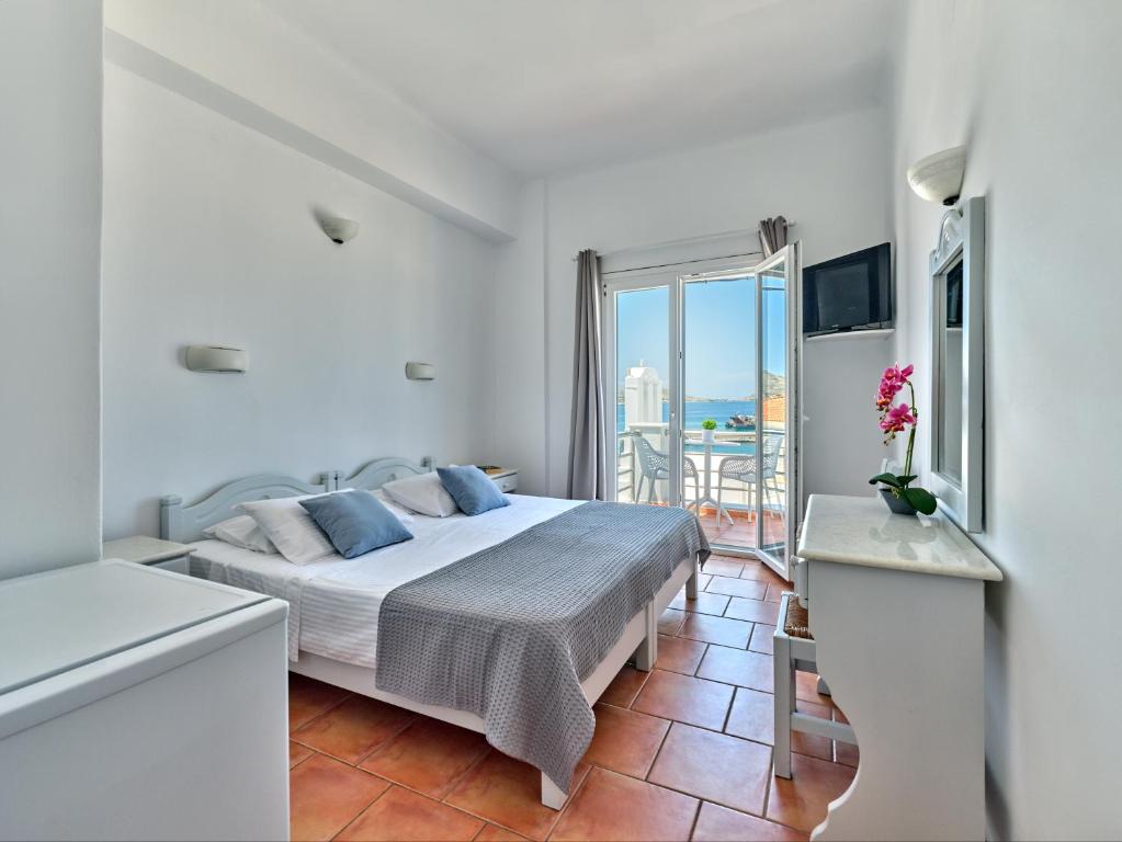 una camera bianca con letto e balcone di Hotel Galini a Naoussa