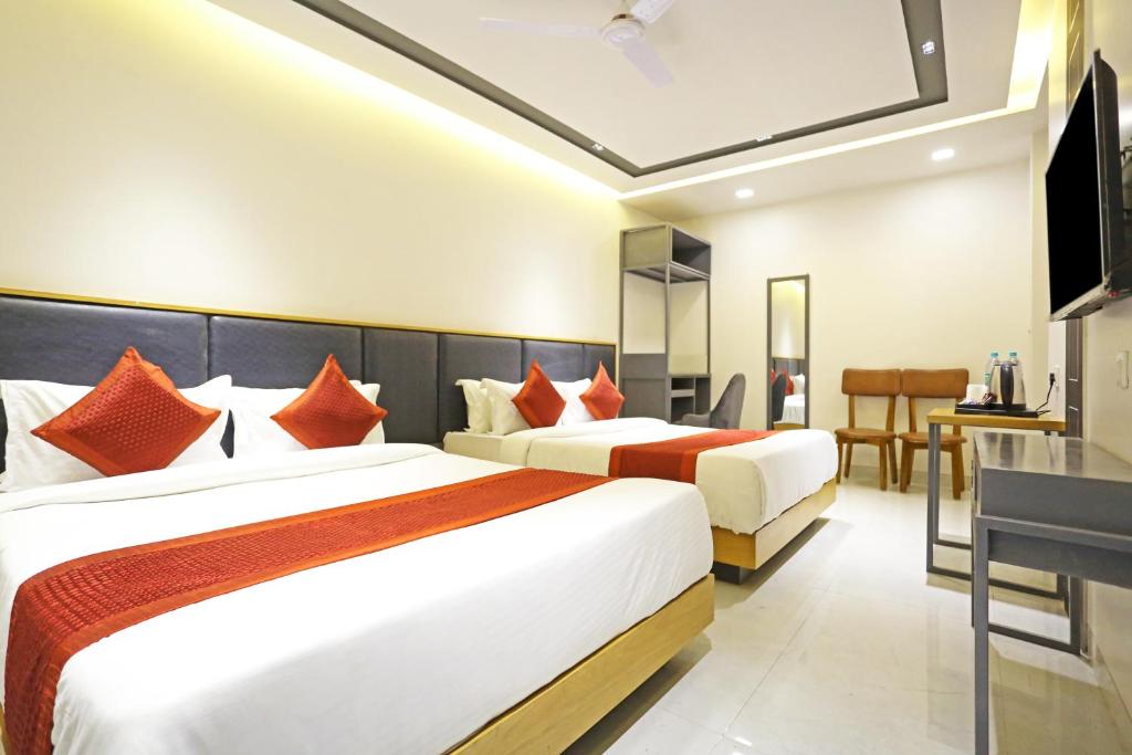 Habitación de hotel con 2 camas y escritorio en Applewood Residency - Free Airport transffer en Nueva Delhi