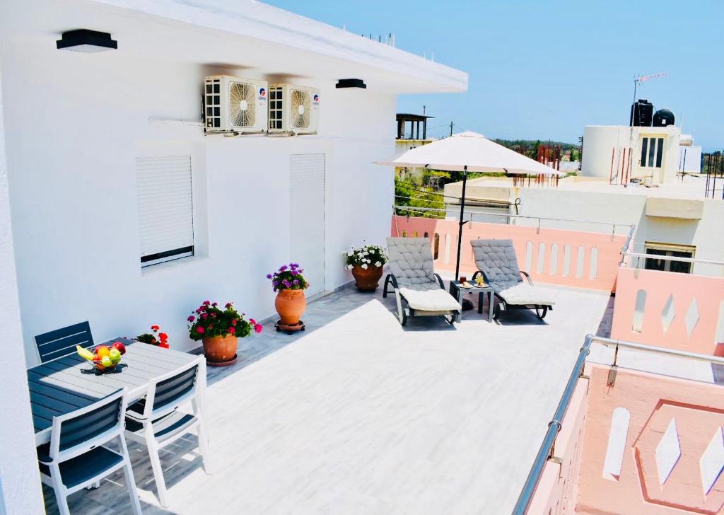 a patio with a table and chairs on a roof at Cozy Renovated Apartment "Filoxenia" in Kato Daratso