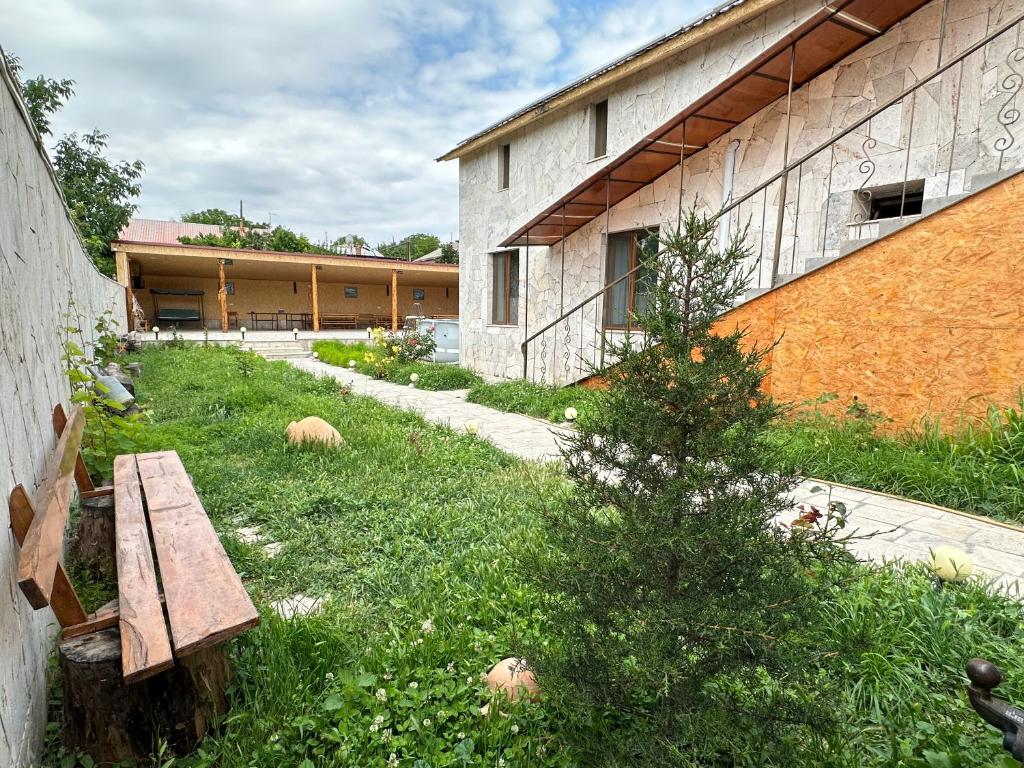 un banc dans l'herbe à côté d'un bâtiment dans l'établissement White House, à Yeghegnadzor