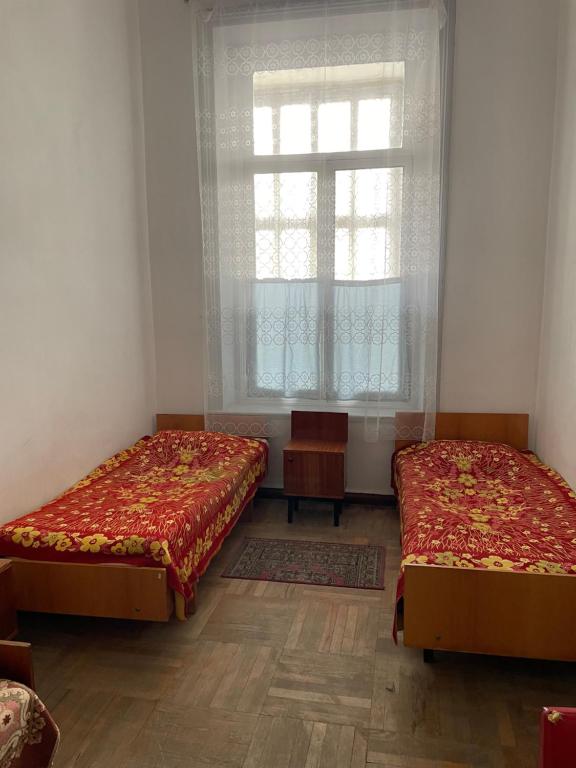 due letti in una stanza con una finestra di Firuza Hostel a Borjomi