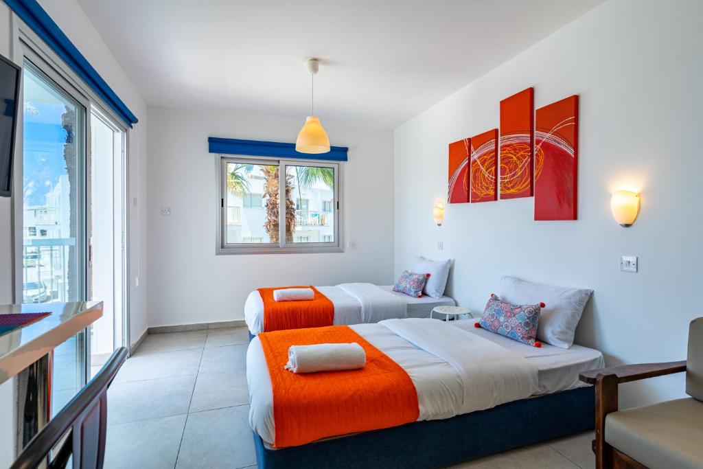 2 camas en una habitación con ventana en Tangerine Studio with Pool in Ayia Napa en Ayia Napa