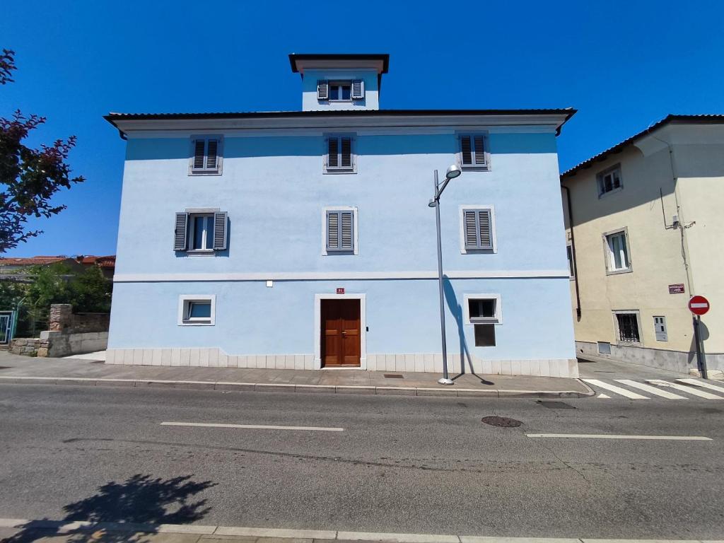 a white building with a red door on a street at Silvo Apartments in Koper