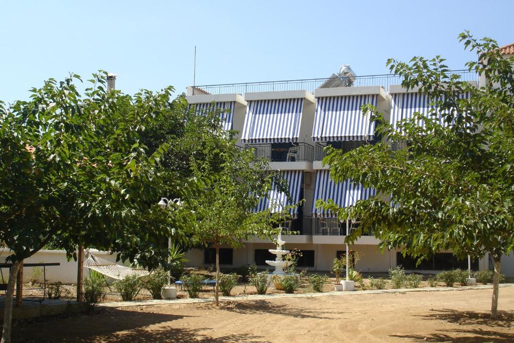 an apartment building with trees in front of it at Demos Studios in Kandia