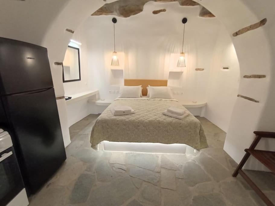 um quarto branco com uma cama e uma casa de banho em Sea Melody Tinos em Ayios Sostis