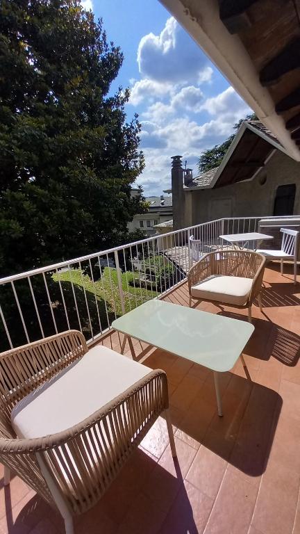 d'une terrasse avec 2 chaises et une table blanche. dans l'établissement Una magnolia in Cademartori, à Blevio