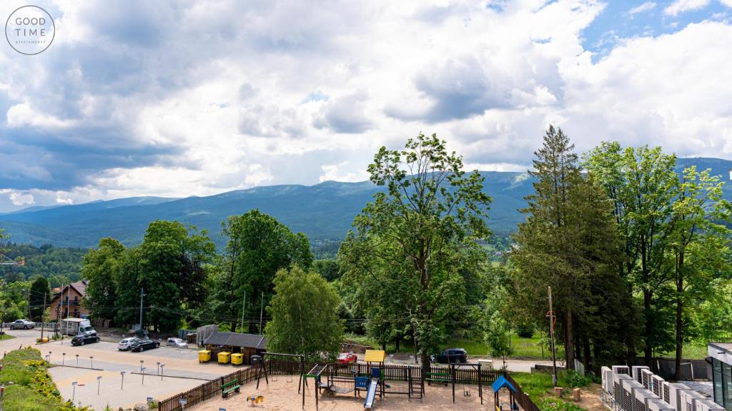 a view of a parking lot with mountains in the background at Apartamenty Good Time - Górna Resort in Szklarska Poręba