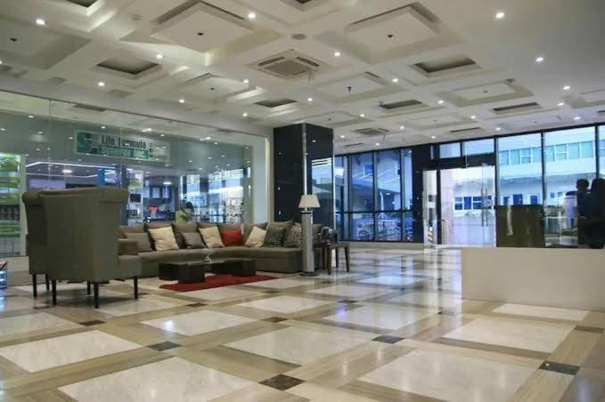 a lobby with couches and tables in a building at ADB Avenue Tower Ortigas Manila in Manila