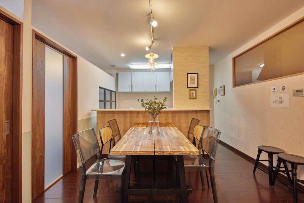 a dining room with a wooden table and chairs at SuiteRoom Hana in Osaka