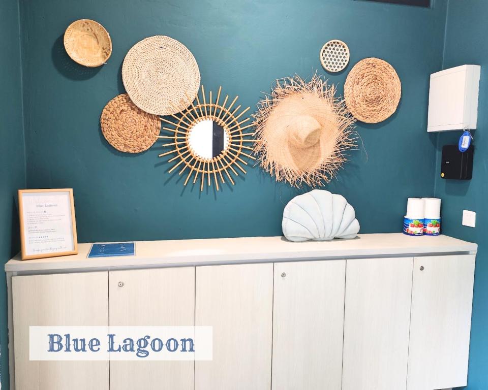 une chambre bleue avec des chapeaux de paille sur le mur dans l'établissement Roxy Sematan Townhouse - Blue Lagoon, à Sematan