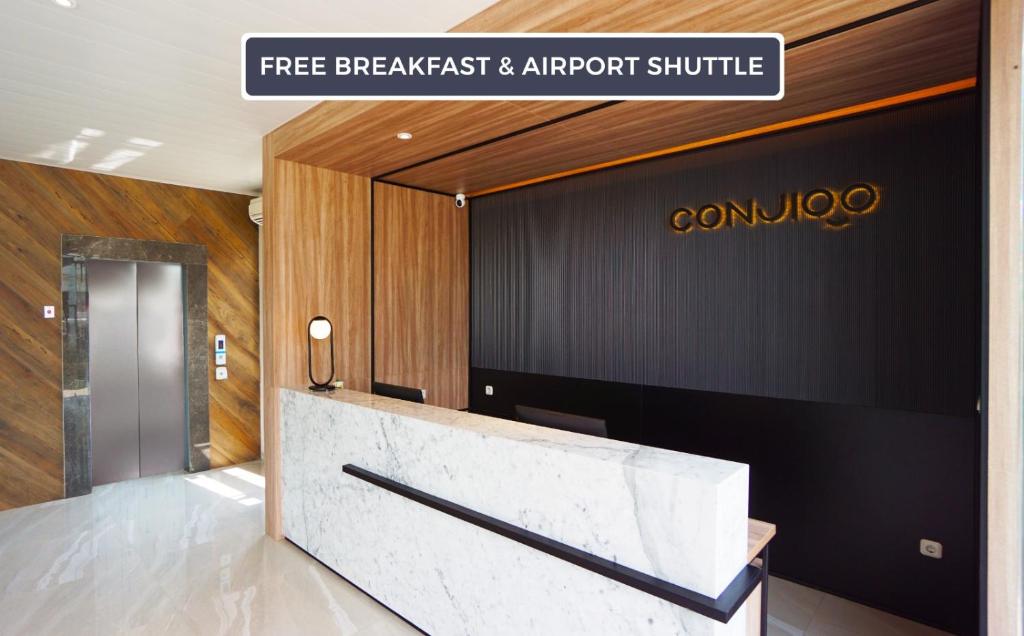 a lobby with a marble counter and a sign at CONJIOO HOTEL at JAKARTA AIRPORT in Tangerang