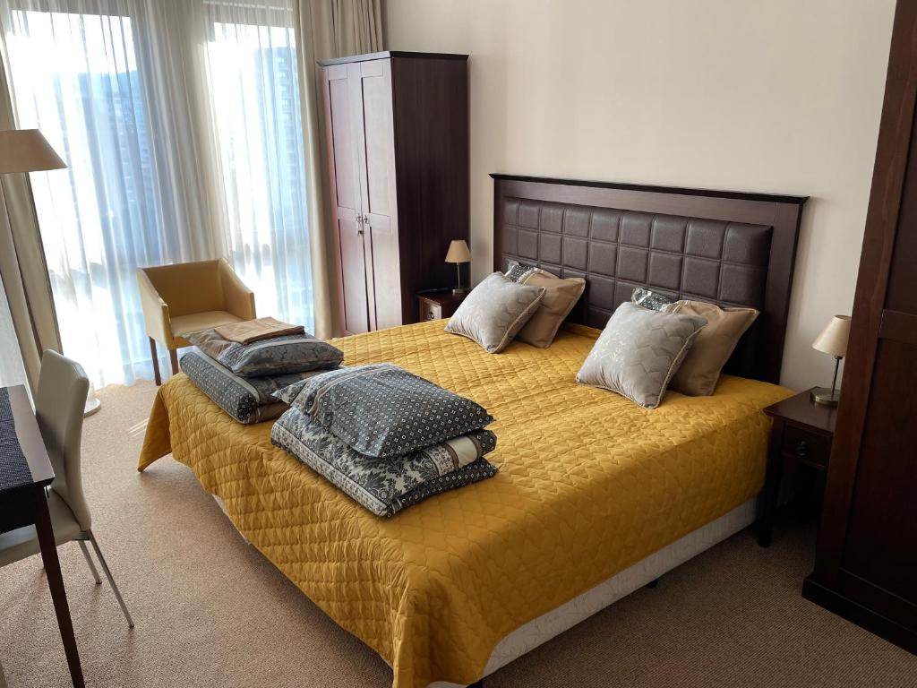 ein Schlafzimmer mit einem Bett mit Decken und Kissen darauf in der Unterkunft ROYAL BEACH & APARTAMENT in Sonnenstrand