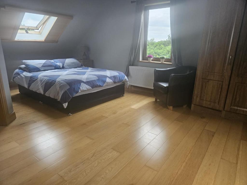 een slaapkamer met een bed, een stoel en een raam bij Celtic Lane in Galway