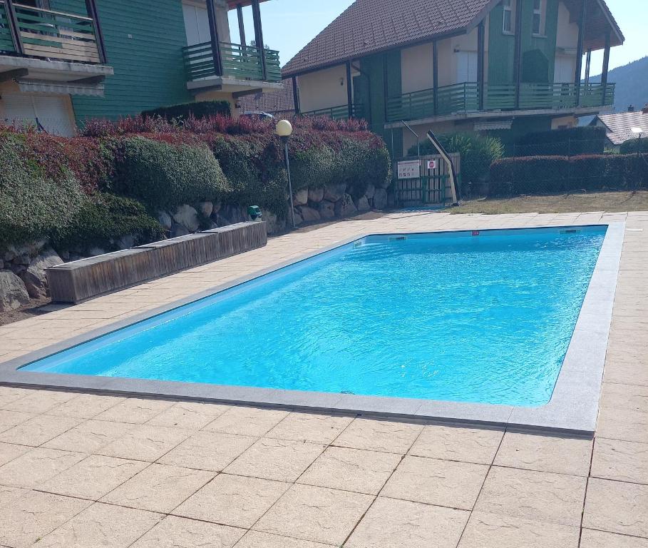 une grande piscine bleue en face d'une maison dans l'établissement Duplex 5 personnes tout compris, à Gérardmer