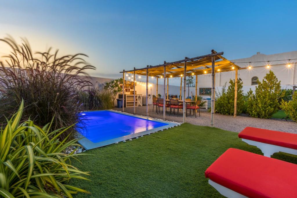 a backyard with a pool and a table and chairs at My Way in Ras al Khaimah