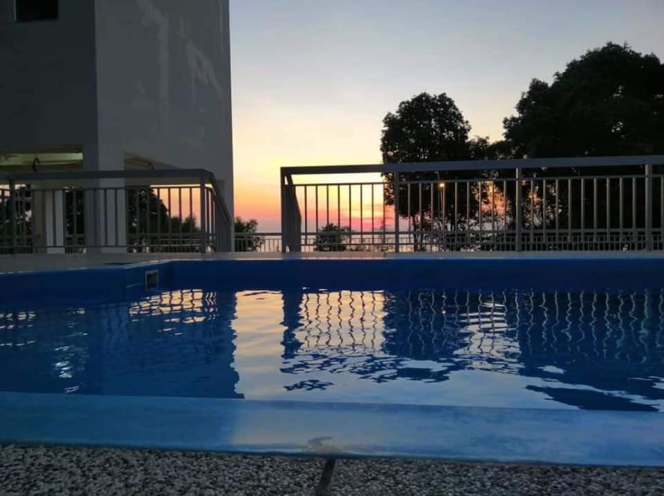 uma piscina com o pôr-do-sol ao fundo em Mk guesthouse em Kuantan