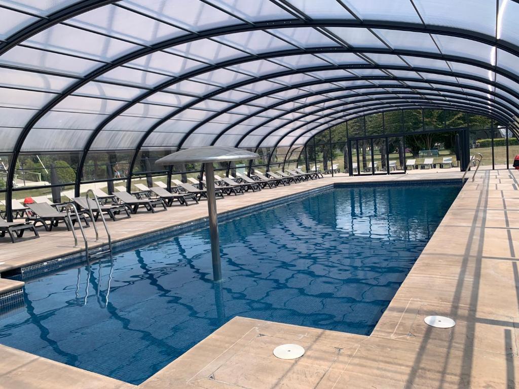 une grande piscine avec un toit en verre dans l'établissement Amirauté Hôtel Golf Deauville, à Deauville