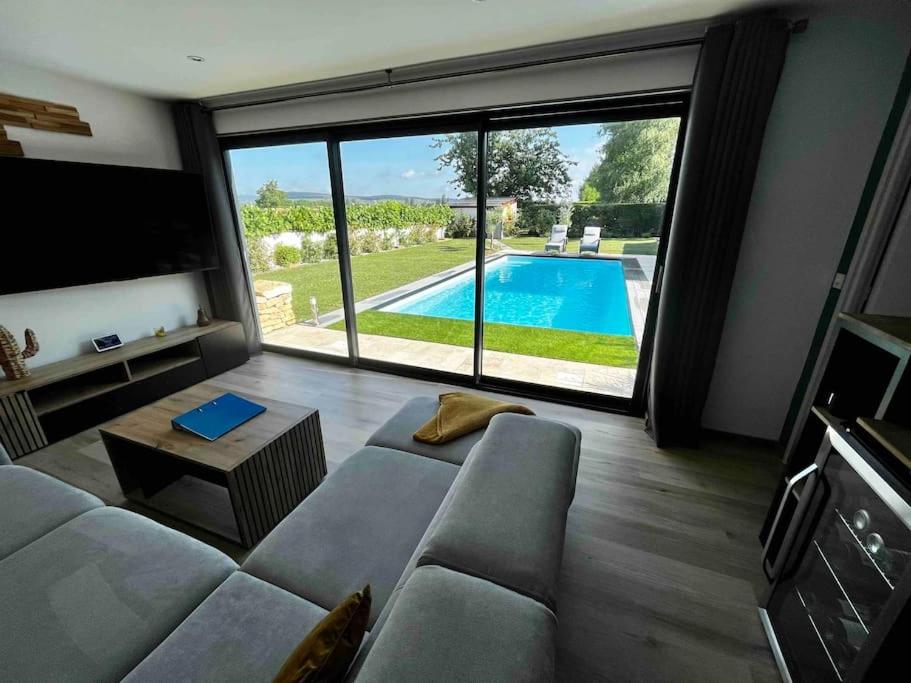 a living room with a couch and a view of a pool at Loft vu sur Pommard in Bligny-lès-Beaune
