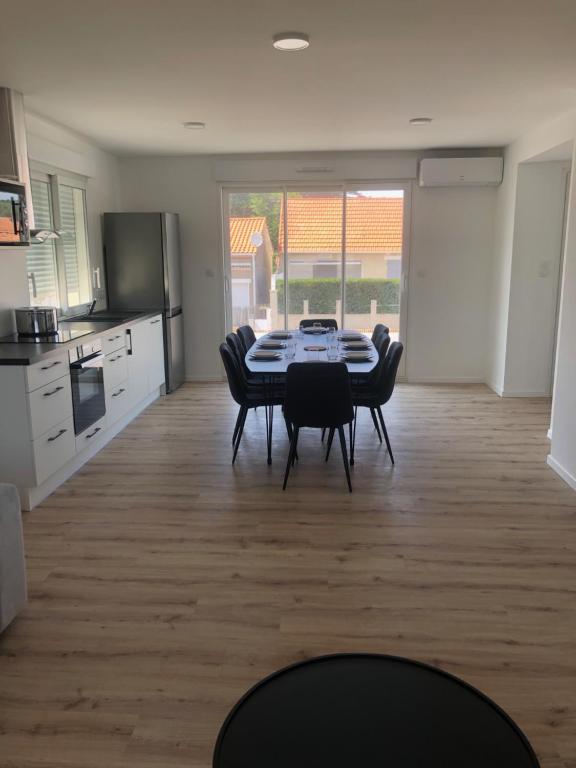 une cuisine et une salle à manger avec une table et des chaises dans l'établissement Bruit de mer, à Saint-Jean-de-Monts