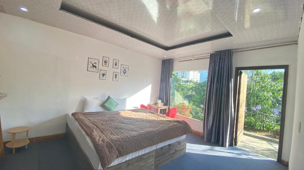 1 dormitorio con cama y ventana grande en Tay Bac Sky Homestay, en Sa Pa