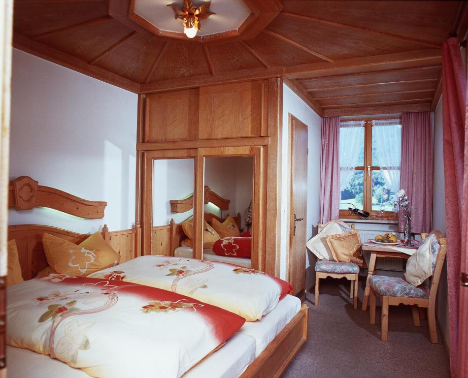 a bedroom with two beds and a wooden ceiling at Pension / Ferienwohnungen Ludwig in Rimbach