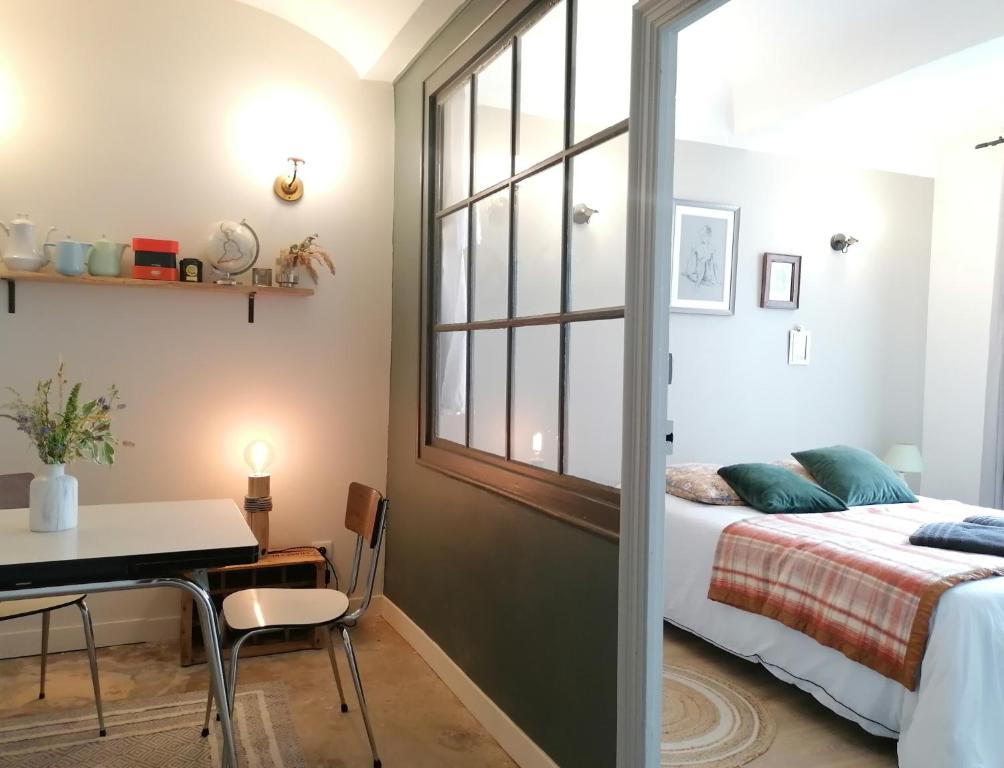 1 dormitorio con cama, escritorio y ventana en Charmante suite indépendante en maison de village, en Loriol-sur-Drôme