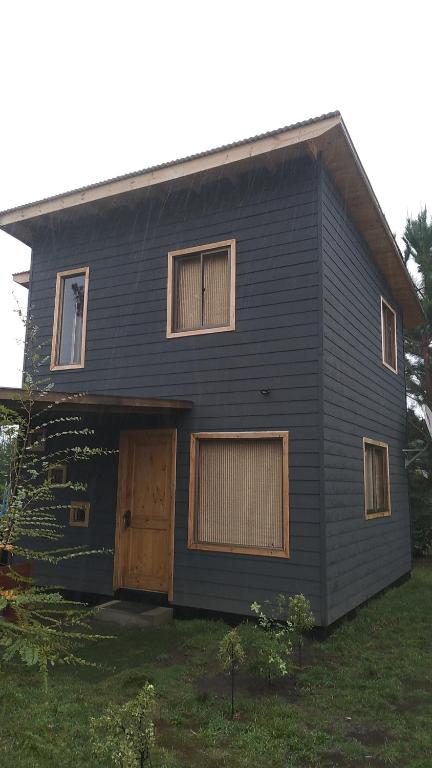 a black house with a brown door and windows at Cabañas los 7 lagos in Panguipulli