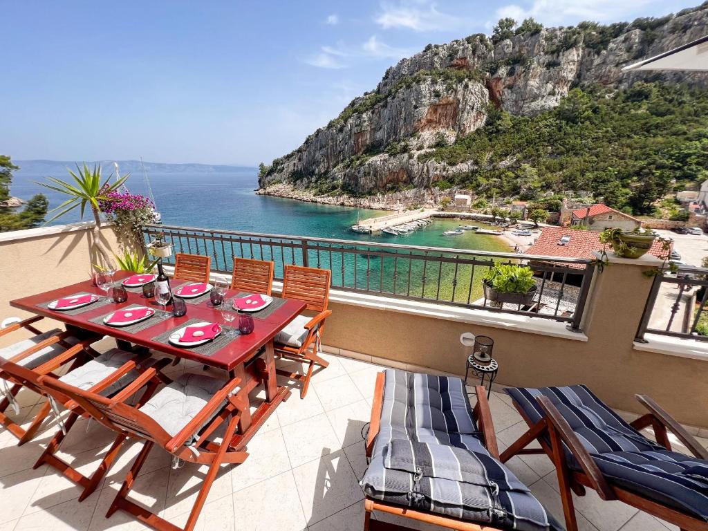a table and chairs on a balcony with a view of the ocean at Apartment Cesare 3 in Zastražišće