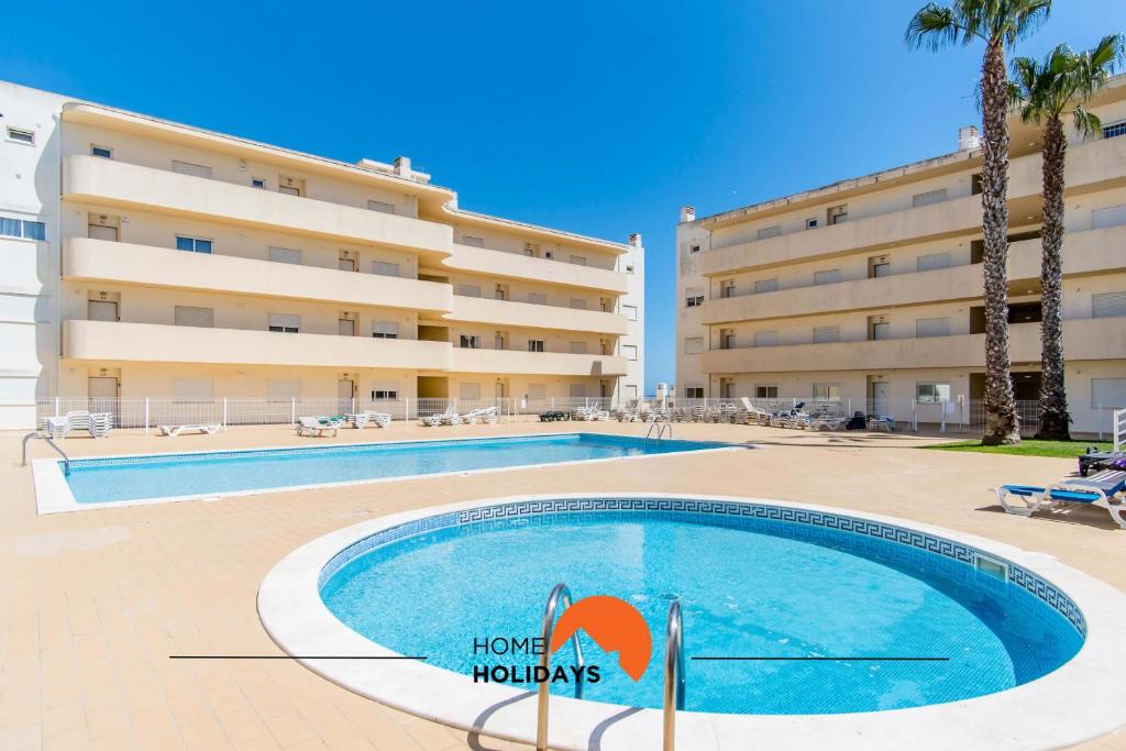 a swimming pool in front of a building at #055 São José V by Home Holidays in Branqueira