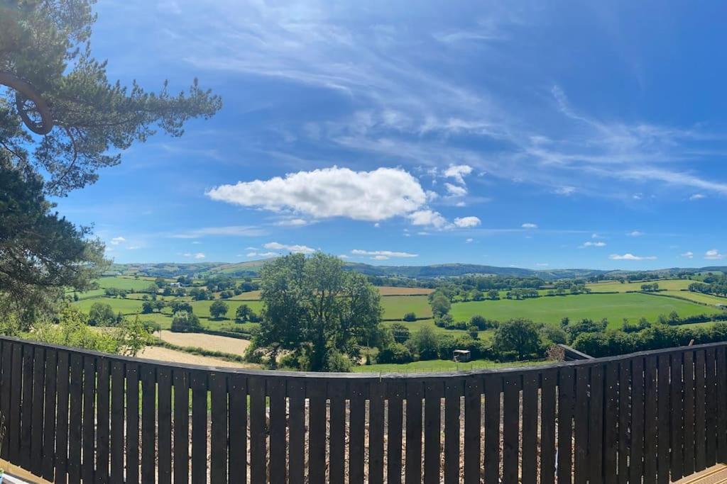 a wooden fence with a view of a green field at 3 bedroom cottage with hot tub and stunning views in Conwy