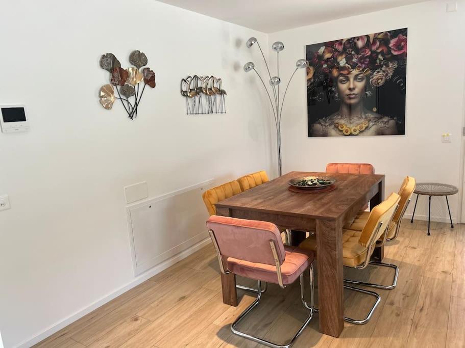 a dining room with a wooden table and chairs at LabPark Modern apartment in Melano