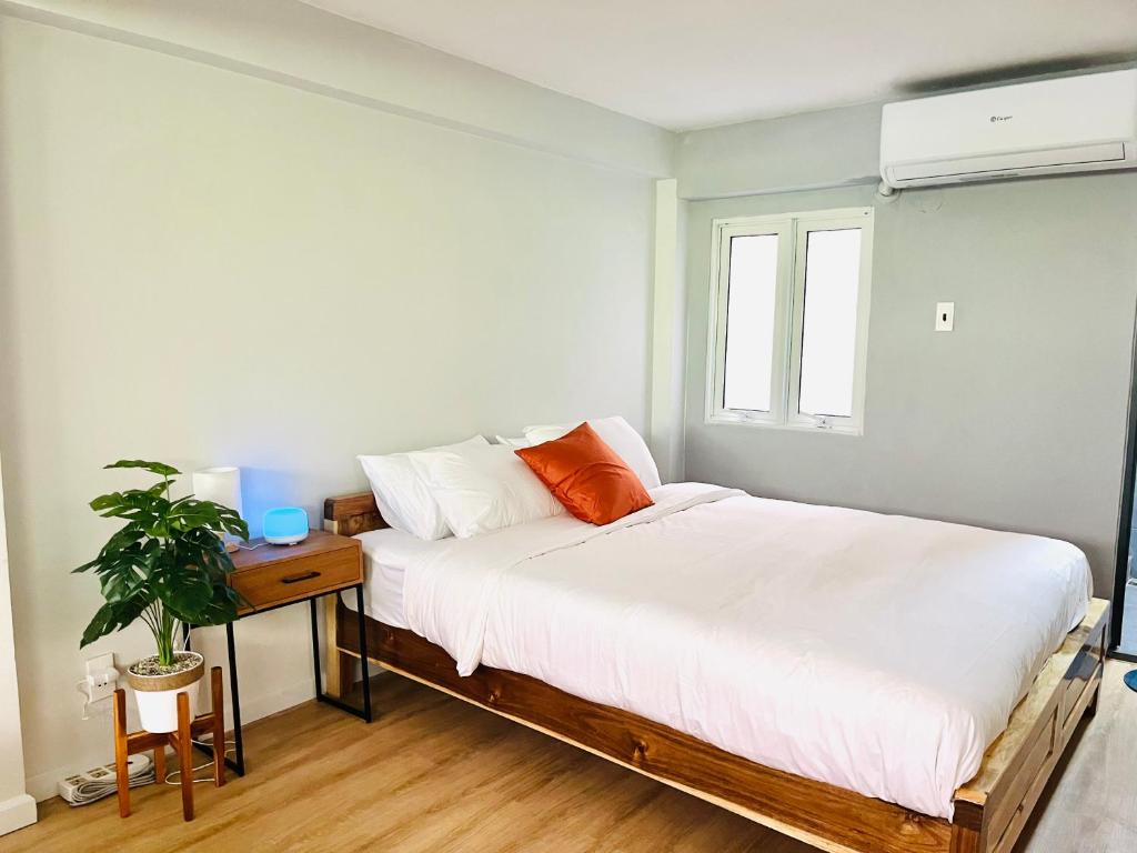 een slaapkamer met een bed met witte lakens en een raam bij The Meeting Place in Ho Chi Minh-stad