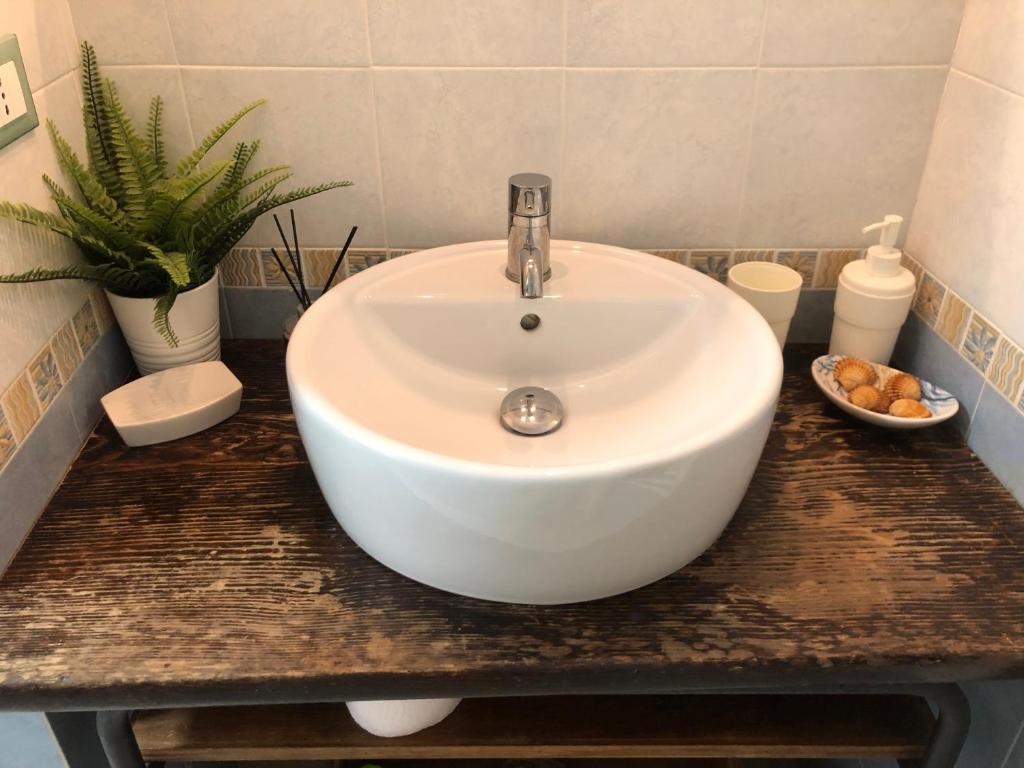 a white sink in a bathroom with a plant at TrentapassidalMare Quinto al mare in Genova