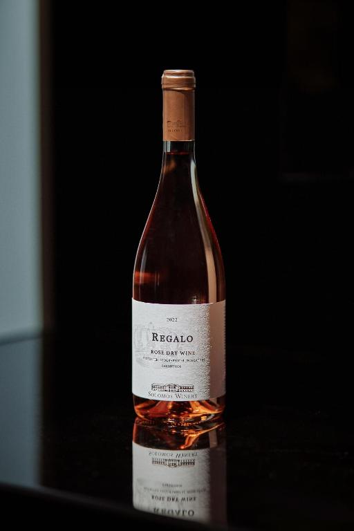 a bottle of wine sitting on a table at Mouzaki's Stone Villas in Volímai