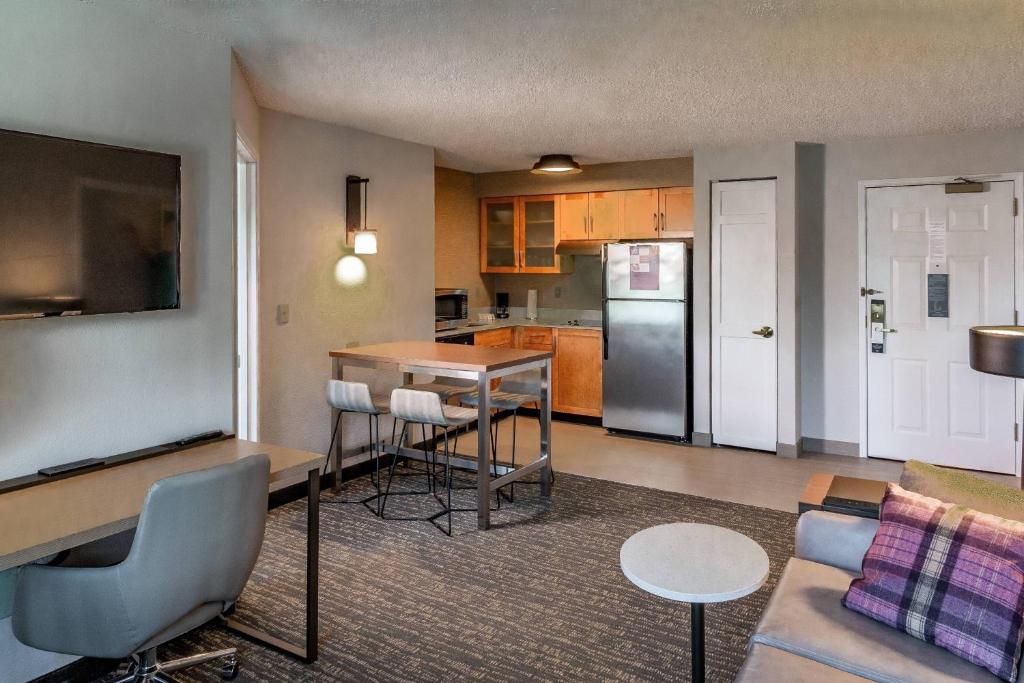 a living room with a couch and a kitchen at Residence Inn by Marriott Anchorage Midtown in Anchorage