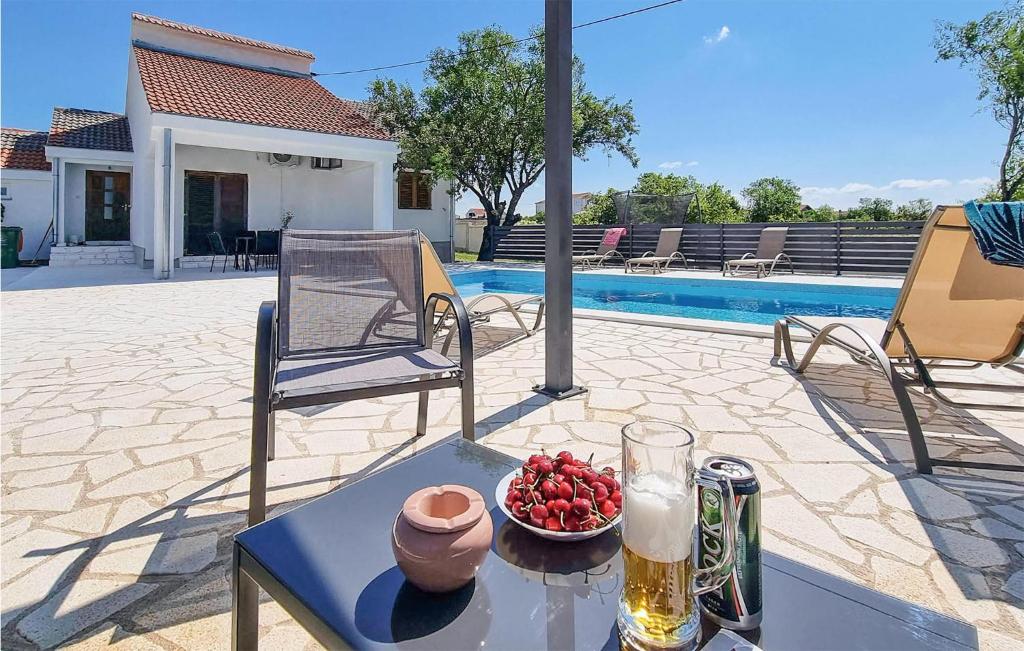 a table with a bowl of fruit and a glass of beer at 4 Bedroom Lovely Home In Miranje Gornje in Miranje Gornje