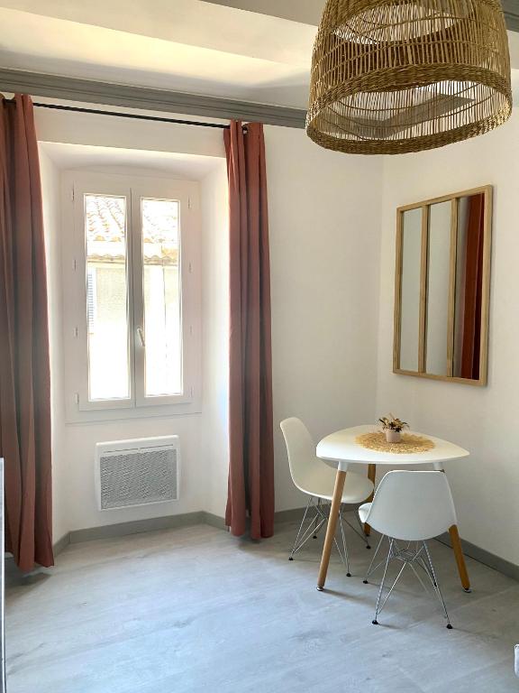 une pièce avec une table, des chaises et une fenêtre dans l'établissement Le studio en Provence, à Saint-Didier