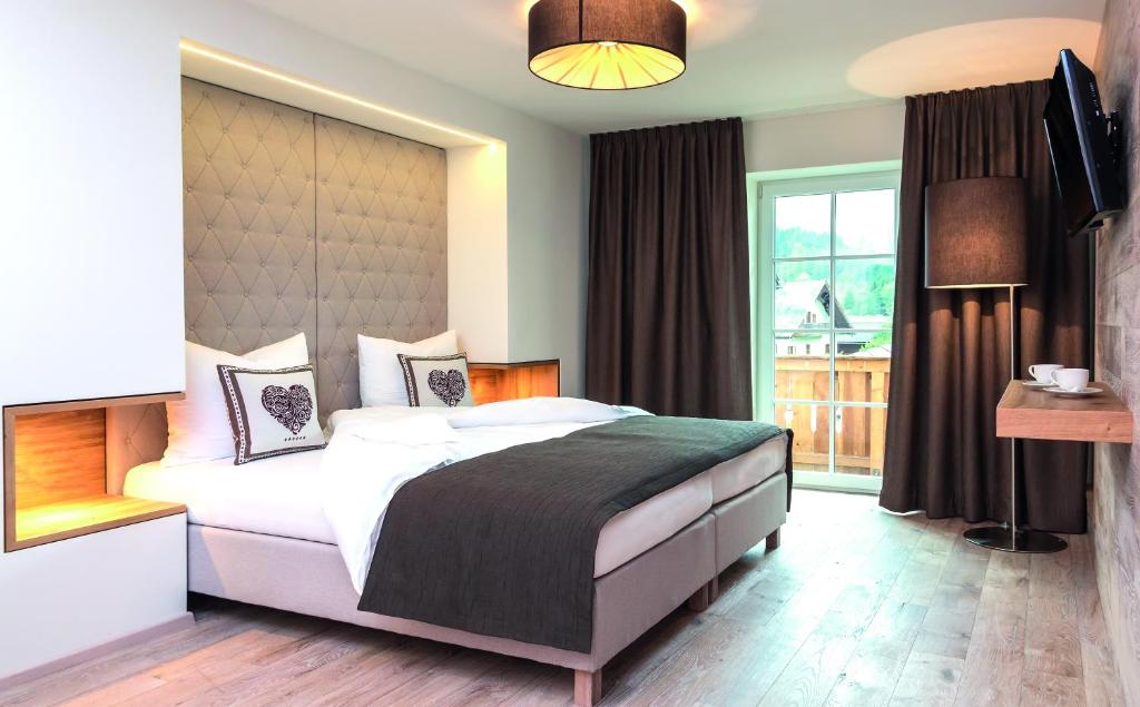 ein Schlafzimmer mit einem großen Bett und einem Fenster in der Unterkunft Hotel am Schloss in Goldegg