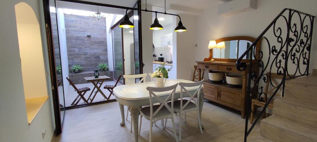 una sala da pranzo con tavolo e sedie bianchi di CasaBala - Near the beach and Barcelona center a Badalona