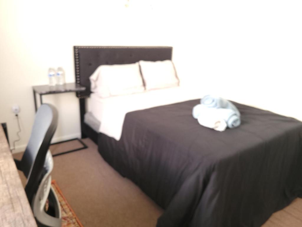 een slaapkamer met een bed met een knuffeldier erop bij Emerald Guest Room 2C in Newark