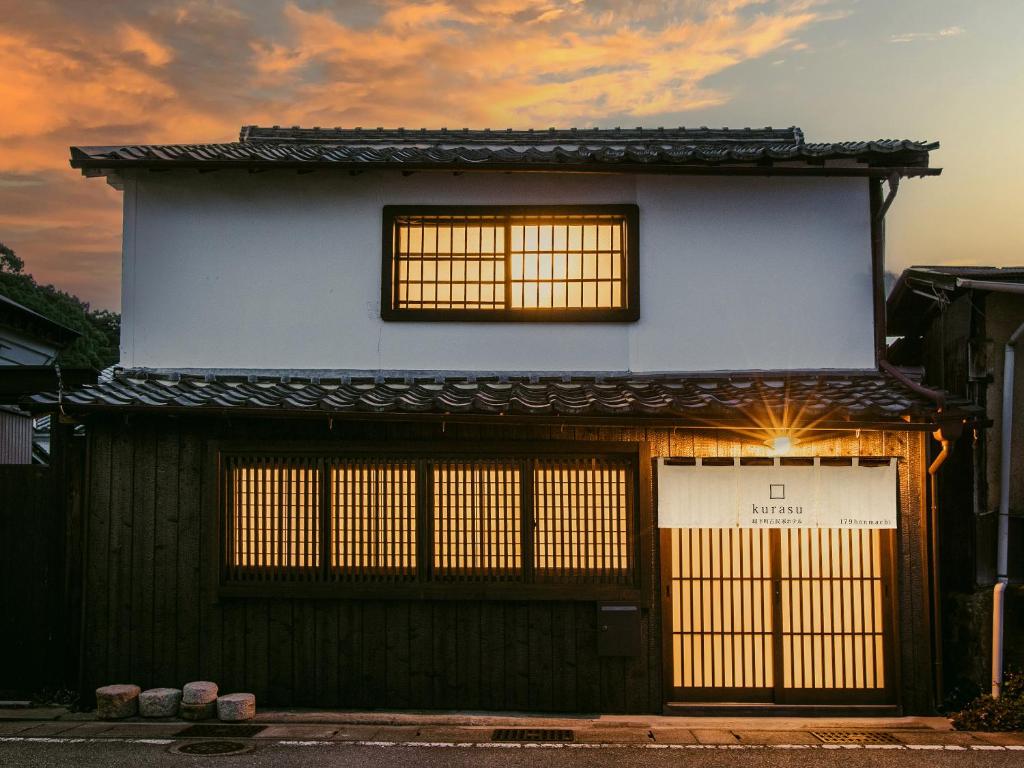 ein Gebäude mit zwei Fenstern und einer Tür in der Unterkunft 龍野城下町古民家ホテル kurasu in Tatsuno