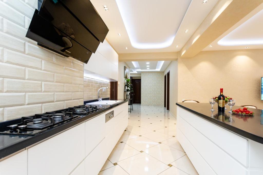 a kitchen with white cabinets and a stove at Luxury Apartment in The City Centre lll in Tbilisi City