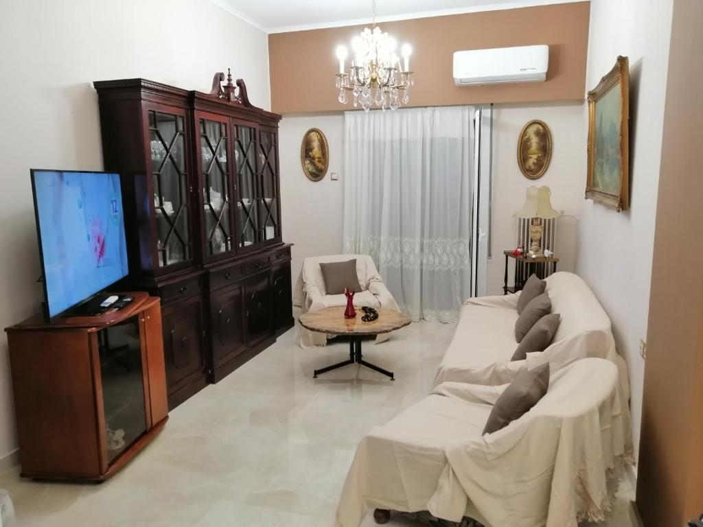 ein Wohnzimmer mit Sofa und Fernseher in der Unterkunft Comfy Apartment For 4 Ppl In Koukaki in Athen