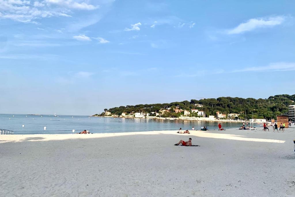 a group of people on a beach near the water at Lovely 4-person apartment 200 m from beaches Cap d'Antibes in Juan-les-Pins