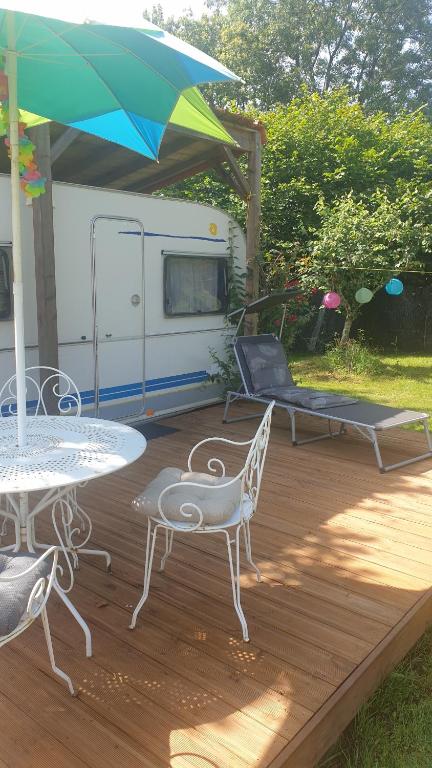 普佐日的住宿－caravane proche puy du fou，一个带桌椅和拖车的庭院
