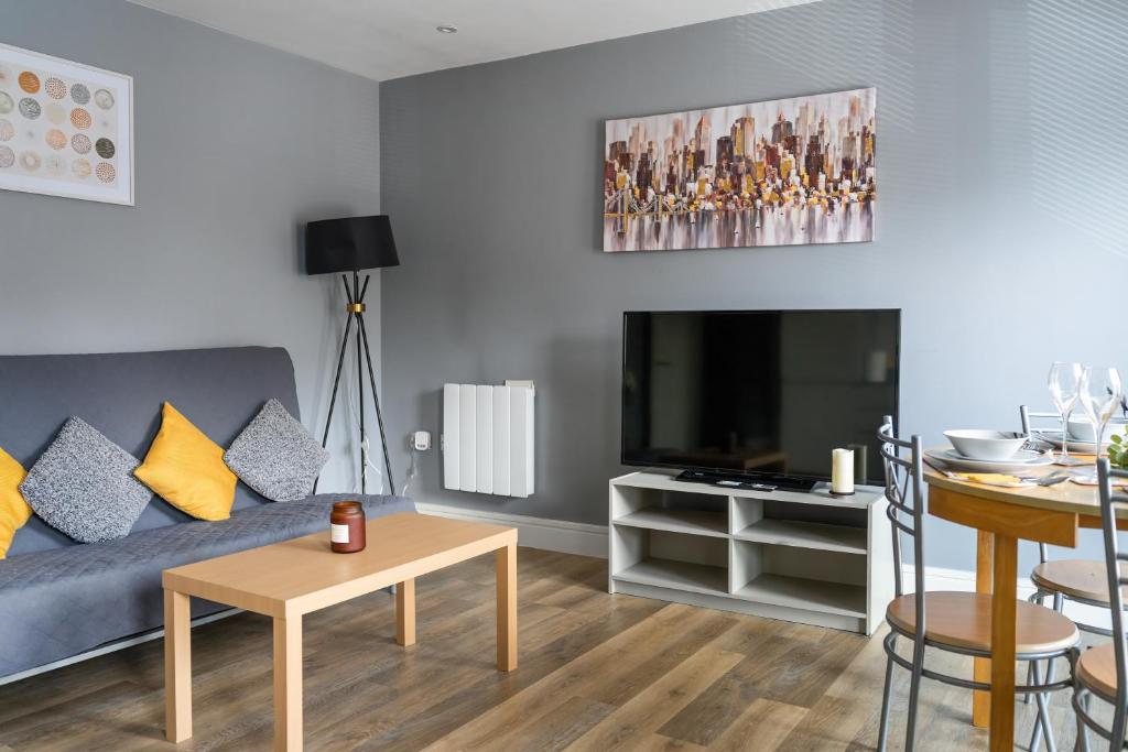 uma sala de estar com um sofá azul e uma televisão em Livestay-One Bed Apt in Slough with FREE Parking em Slough