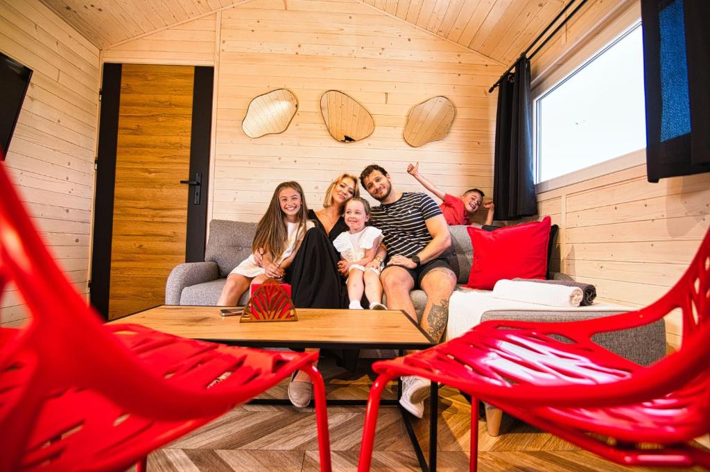 a family sitting on a couch in a room at Holiday Park Zator Resort & Spa in Zator