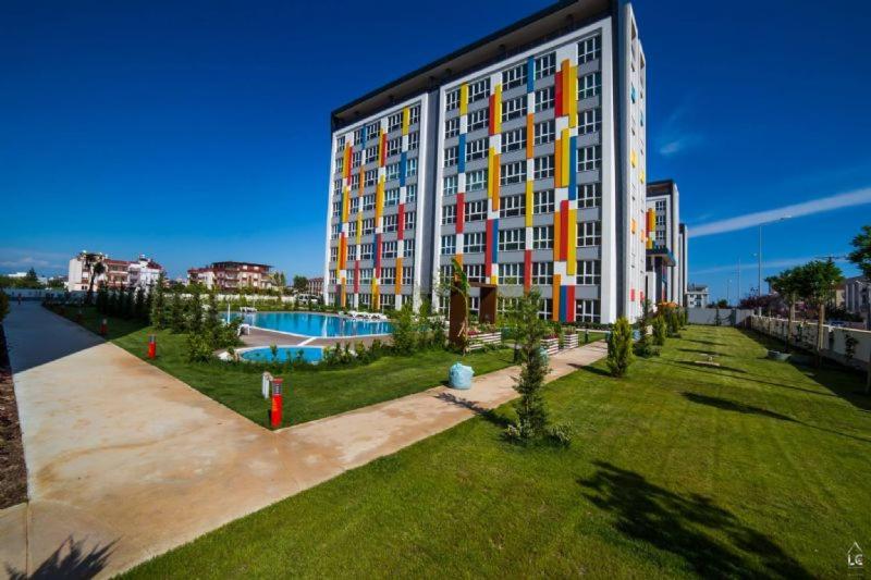 een groot gebouw met een zwembad ervoor bij Selin's apartment with pool view in Antalya