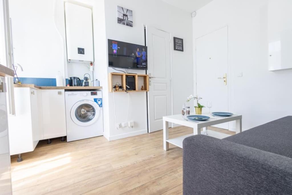 オルリーにあるAppartement 450 m gare RER Cのリビングルーム(洗濯機、テーブル付)
