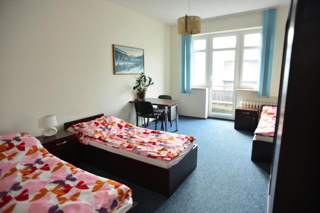 Cette chambre comprend 2 lits et une table. dans l'établissement SHIRE Gdynia, à Gdynia